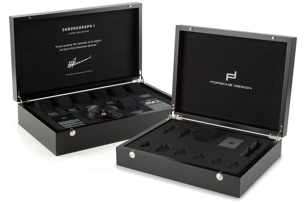 Two open black Porsche Design watch display boxes, one with inserts, info cards and a gauge-like instrument.